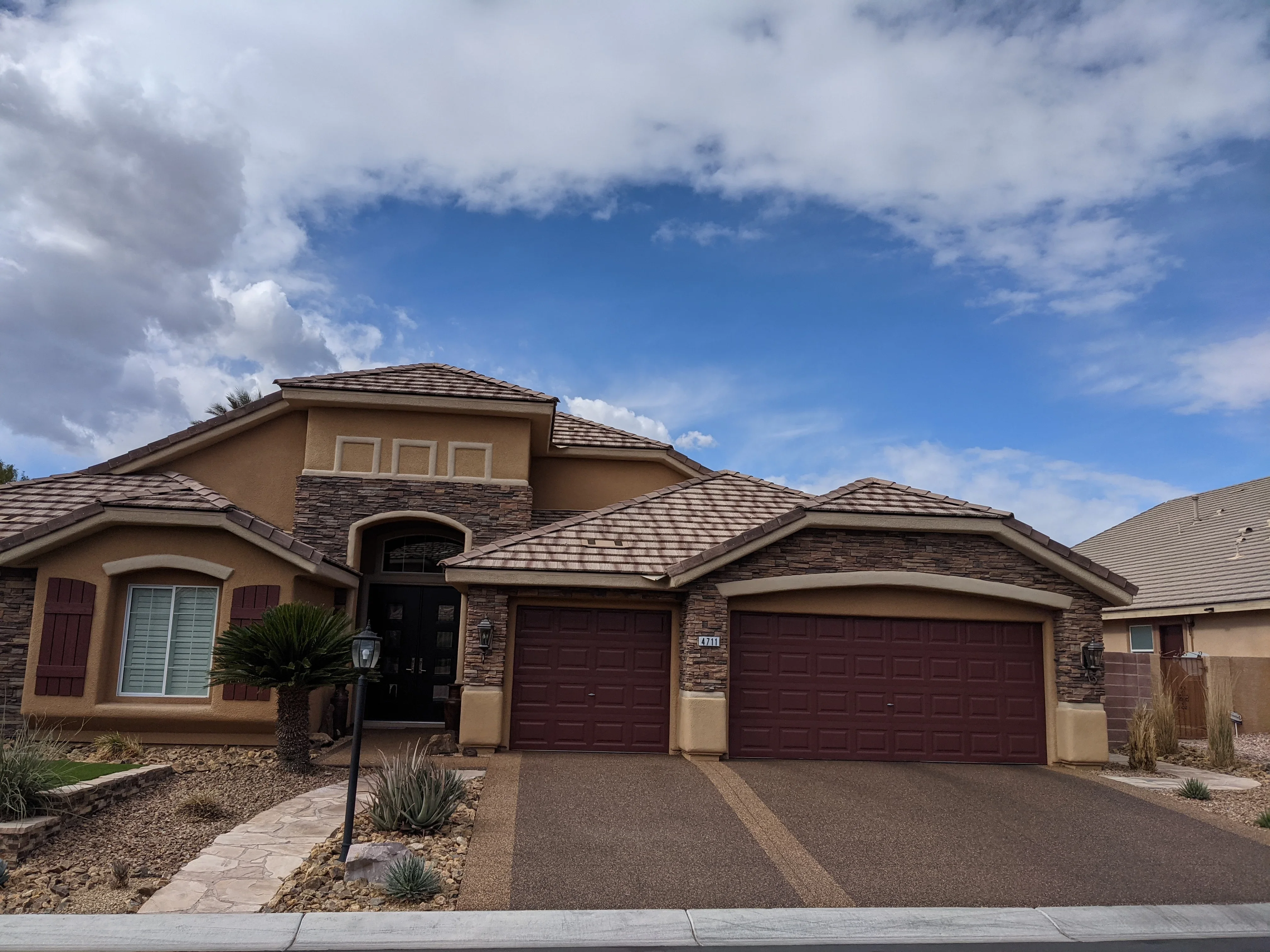Modern desert home with stamped concrete driveway, stone accents, and xeriscaped landscaping