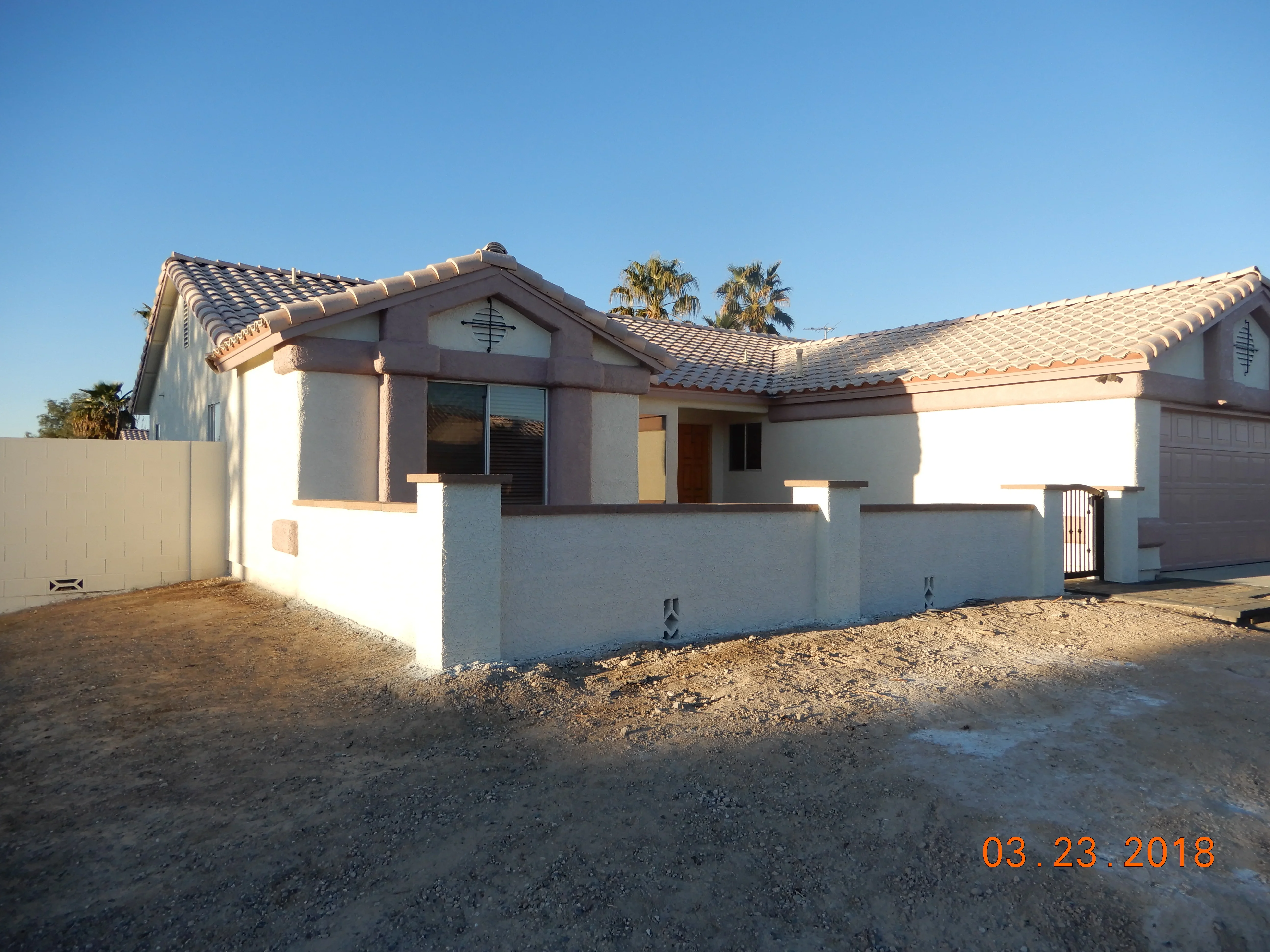 White stucco home with clay tile roof and hardscape foundation work in Las Vegas