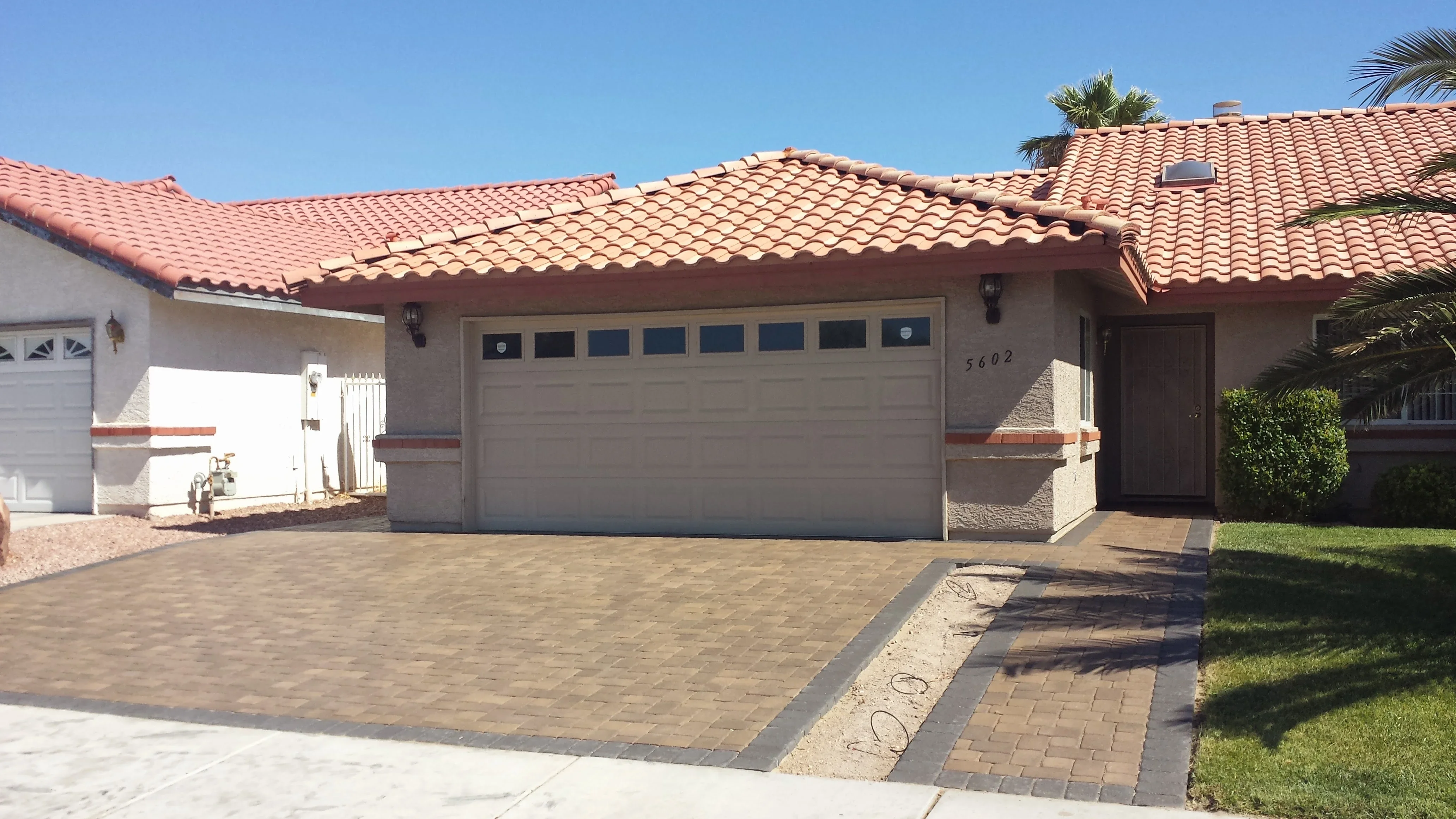 Newly installed clay brick paver driveway with border detail in front of residential home