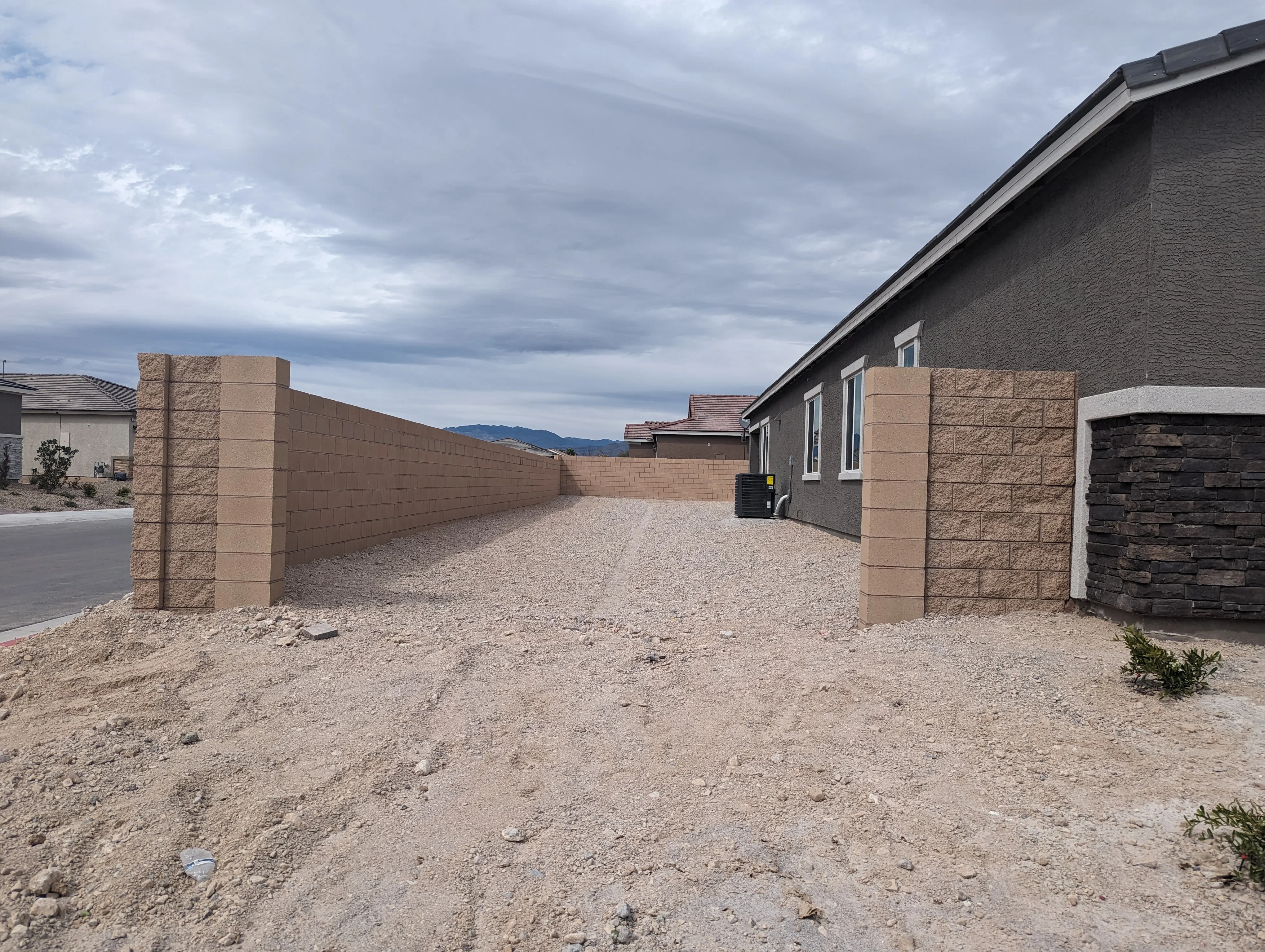 Gravel driveway with stone retaining wall and decorative pillar entries