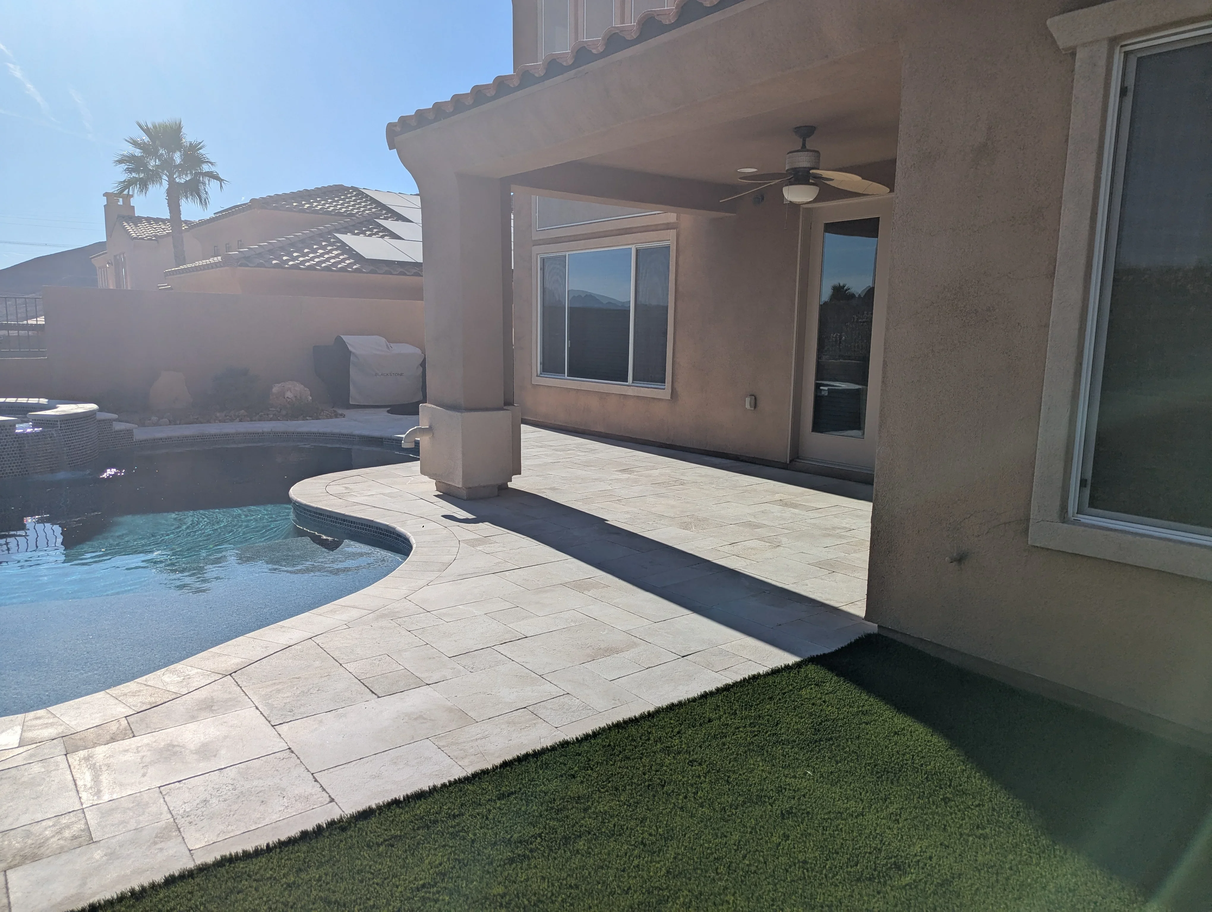 Travertine patio with pool surround, covered pergola, and mountain views in Las Vegas