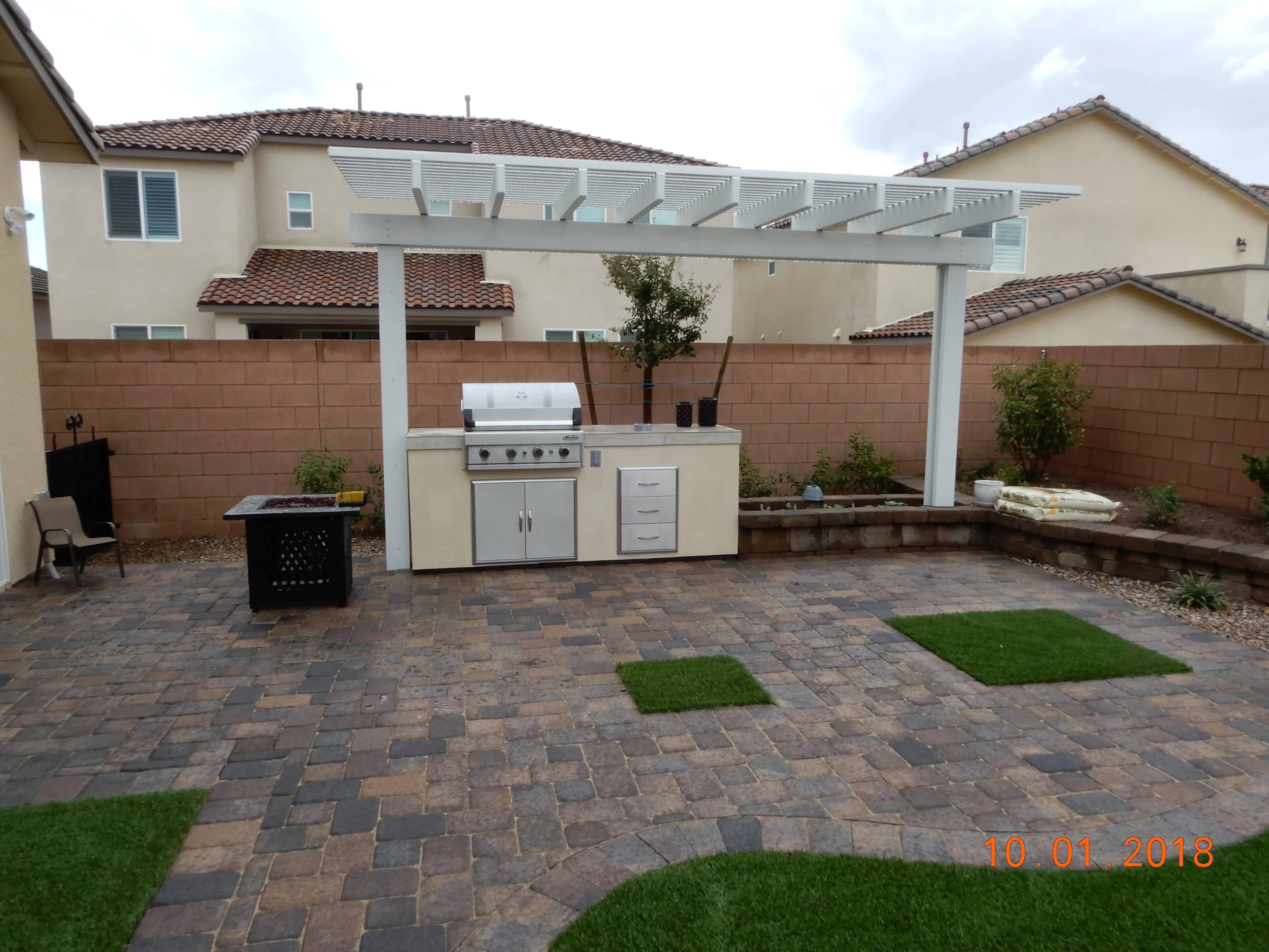 Backyard patio with outdoor kitchen, pergola, and paver installation in Las Vegas