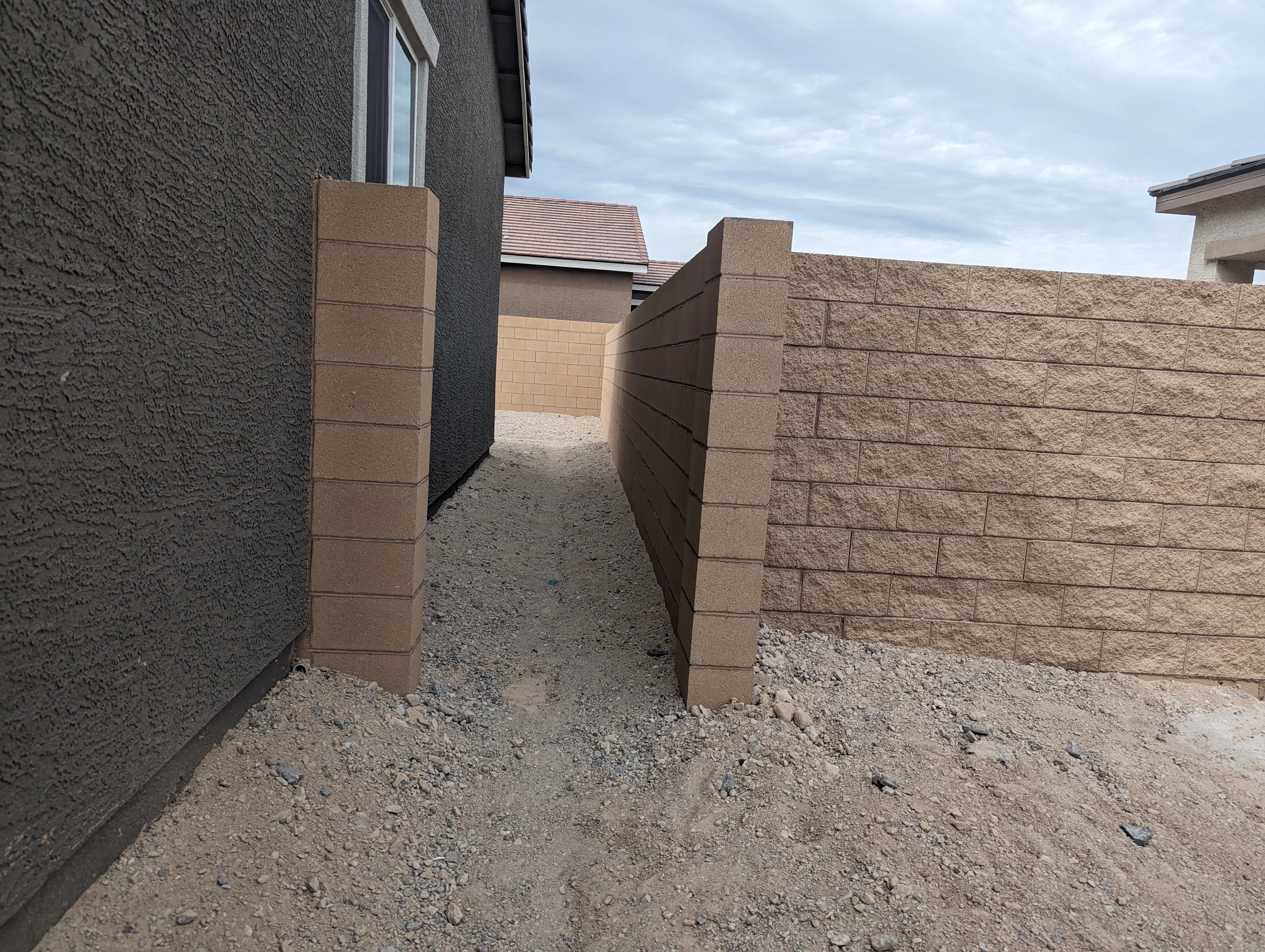 Tan concrete block retaining wall with pillar posts in residential Las Vegas setting