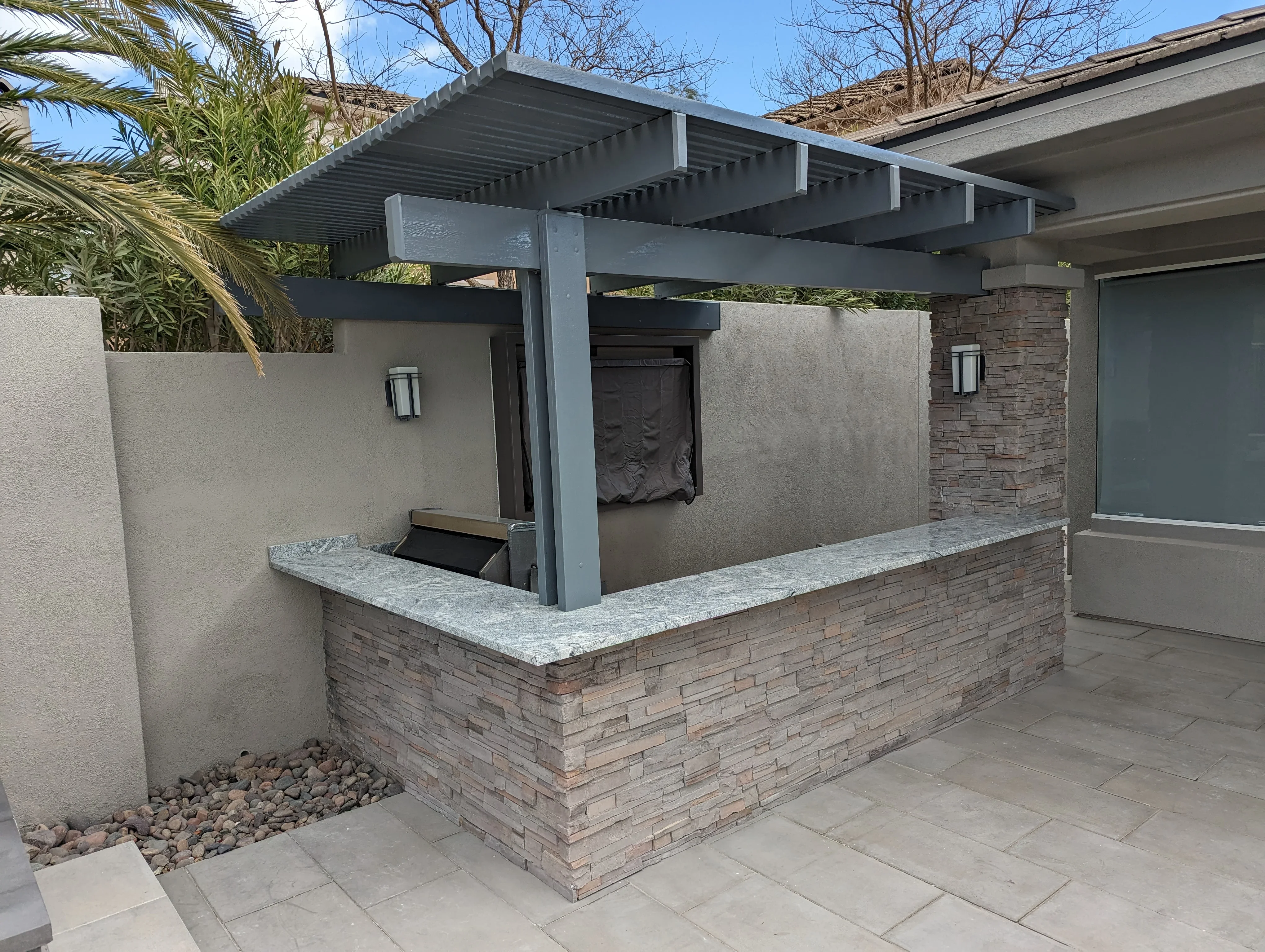 Modern pergola patio with charcoal aluminum frame, brick base, and quartz countertop in Las Vegas