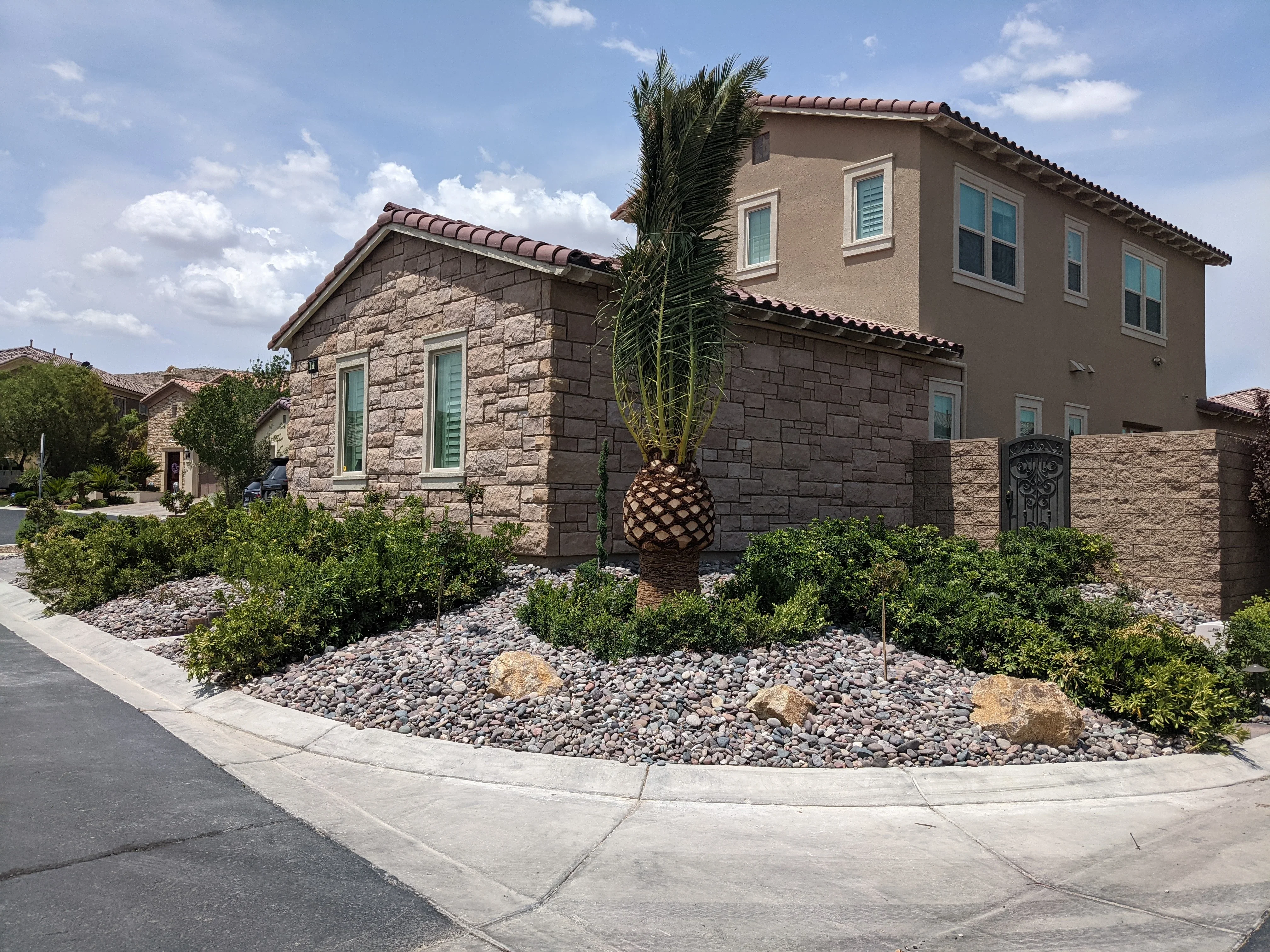 Modern home with river rock landscaping, stone walls, and desert plantings in Las Vegas