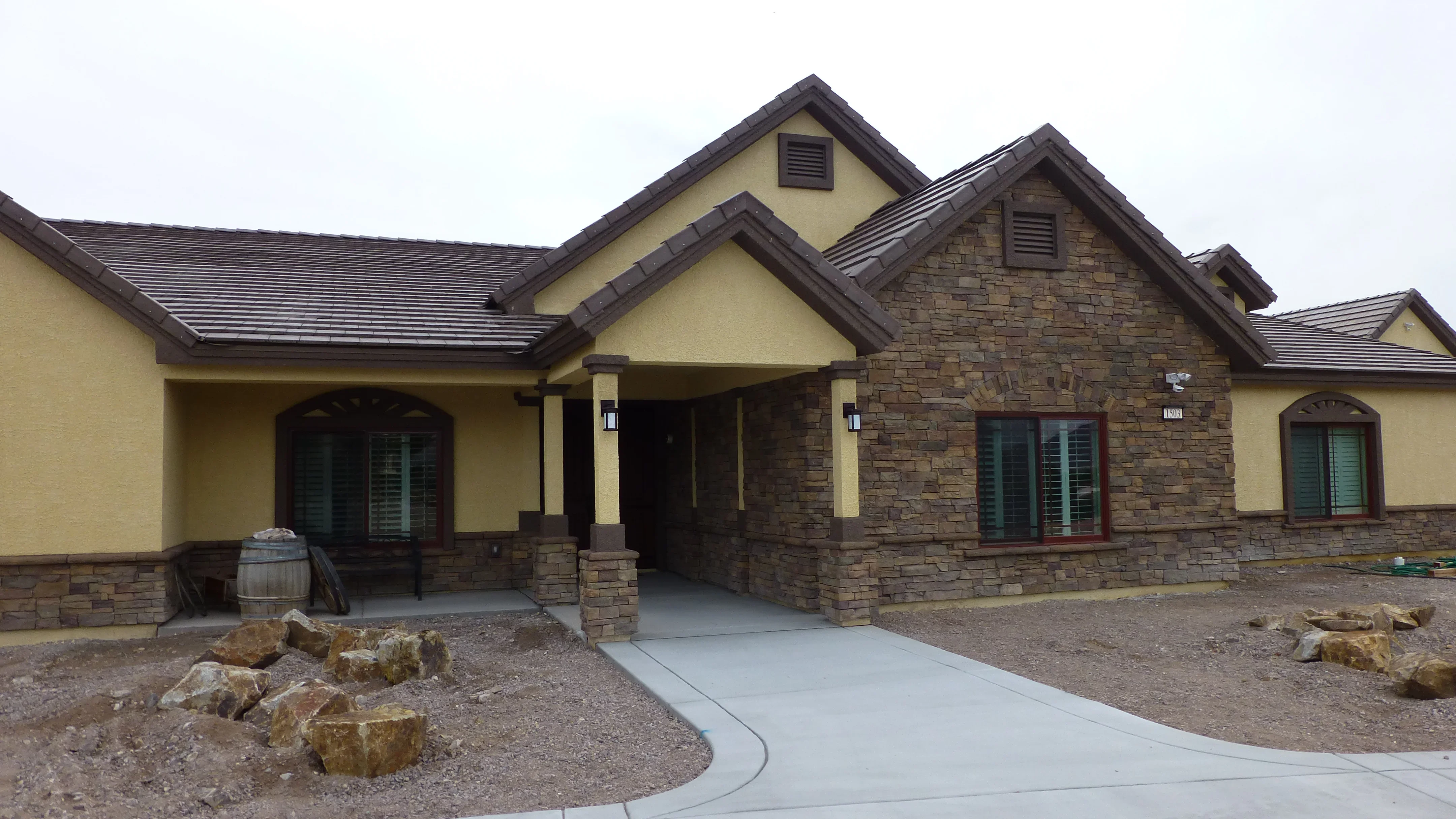 Finished concrete driveway with curved borders and stone landscaping accents at residential home