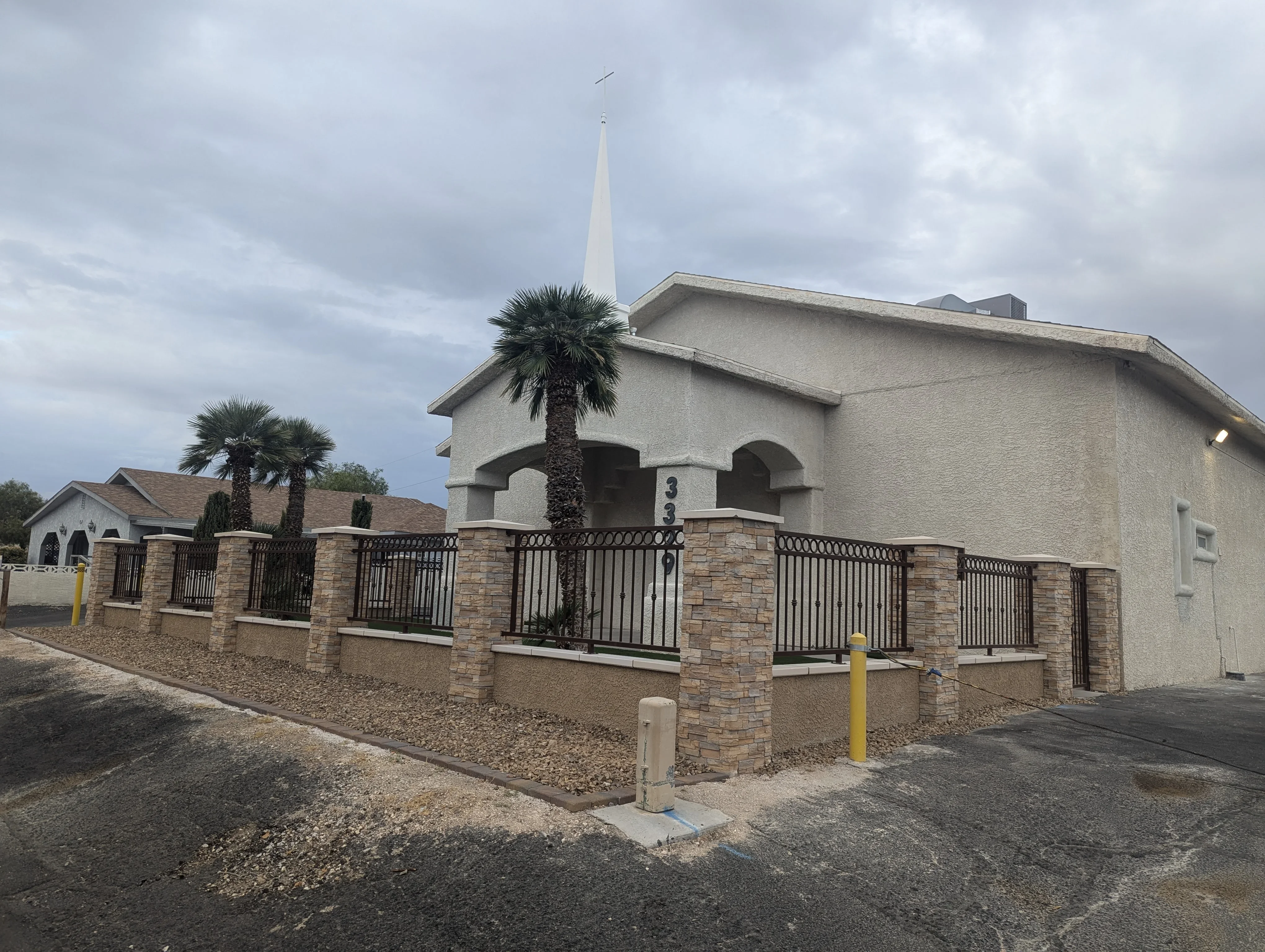 Brick and metal fence with decorative columns surrounding property entrance